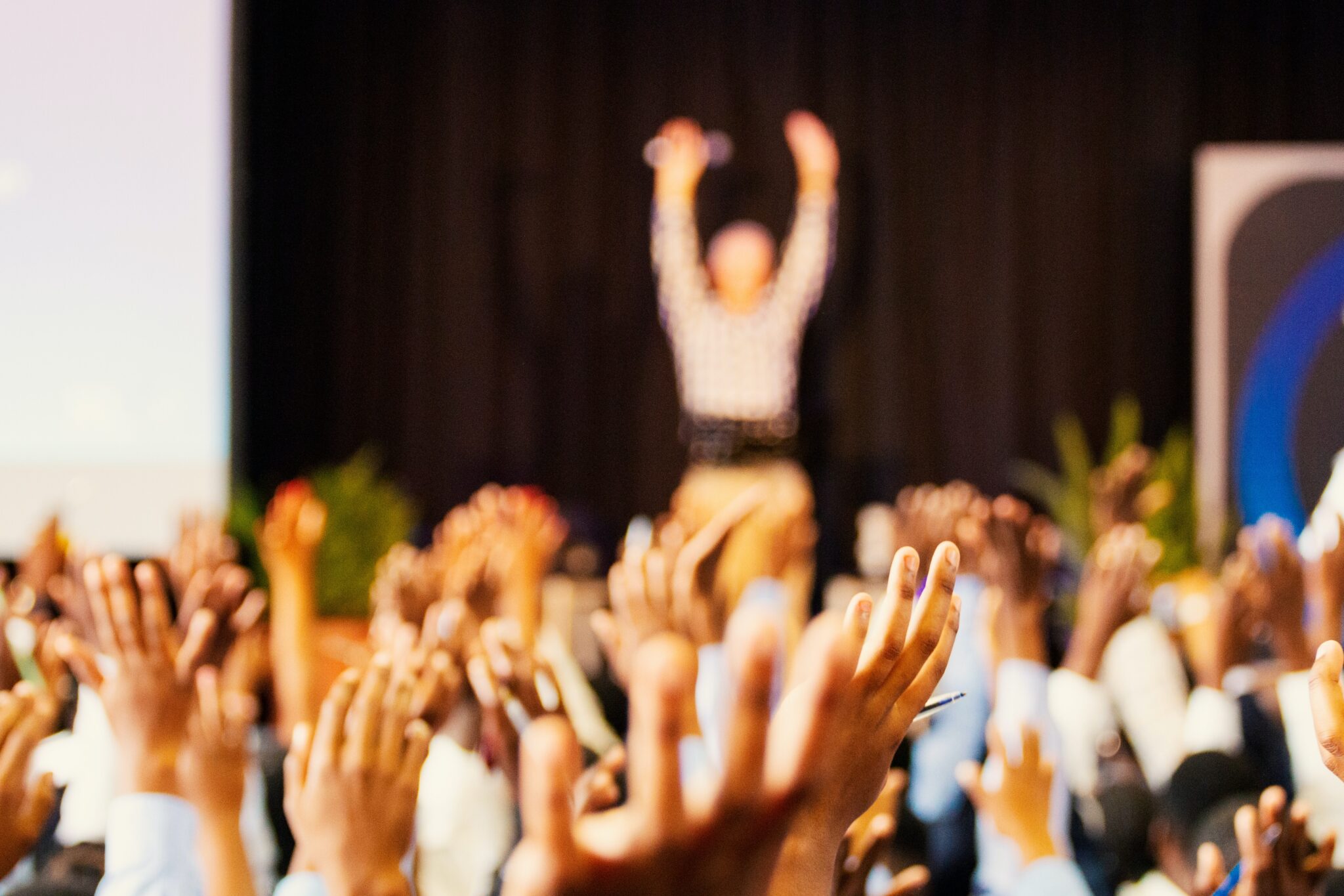 Audience raising hands for presenter